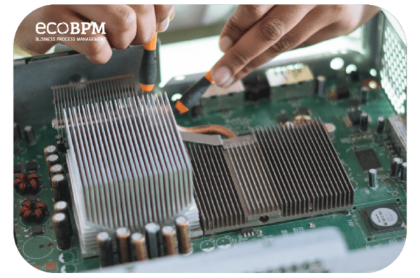 Technician using screwdrivers to work on large heatsinks on a computer motherboard or electronics circuit board.